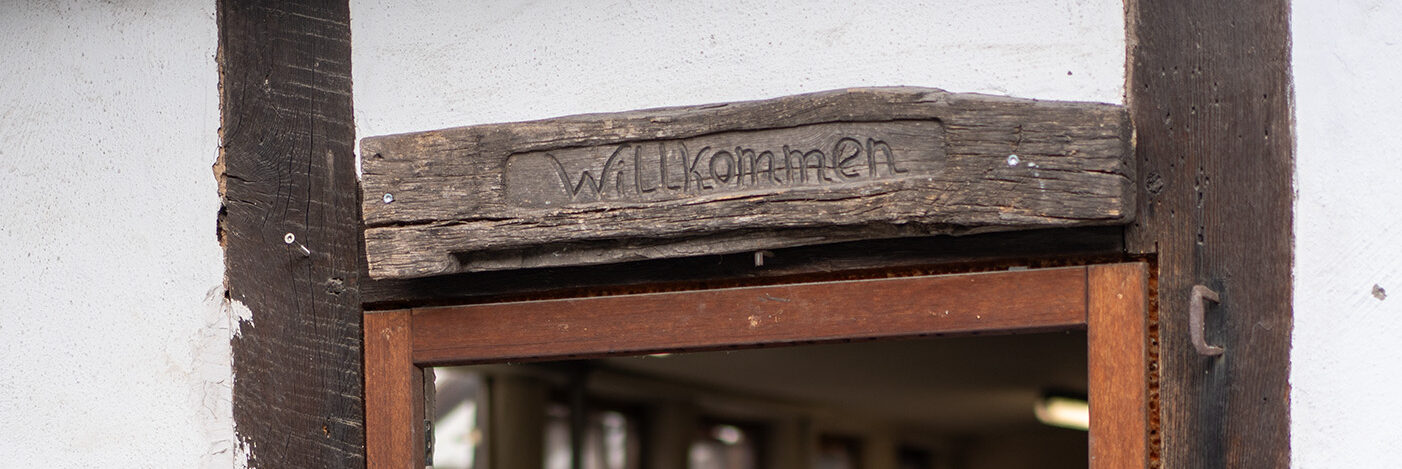 Schild "Willkommen" über einem Fenster auf dem Brothof